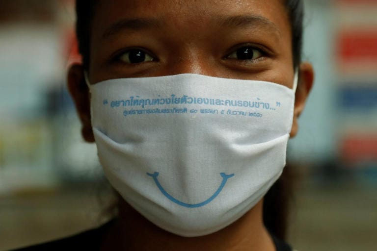 Amazing Thailand welcomes visitors with a beautiful smile behind a face-mask